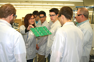Lenze employee educates students from Northbridge High school and Douglas High School on the production process of populating boards with components through the surface mount area.