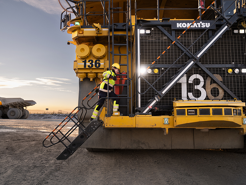Worker climbing up the autonomous trucks steps