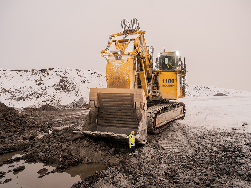 Shovel operator standing by shovel machine