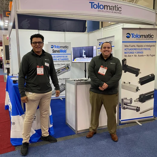 Two sales managers, Giovanni and Alejandro stand in front of the Tolomatic booth at Expo Manufactura in Mexico.