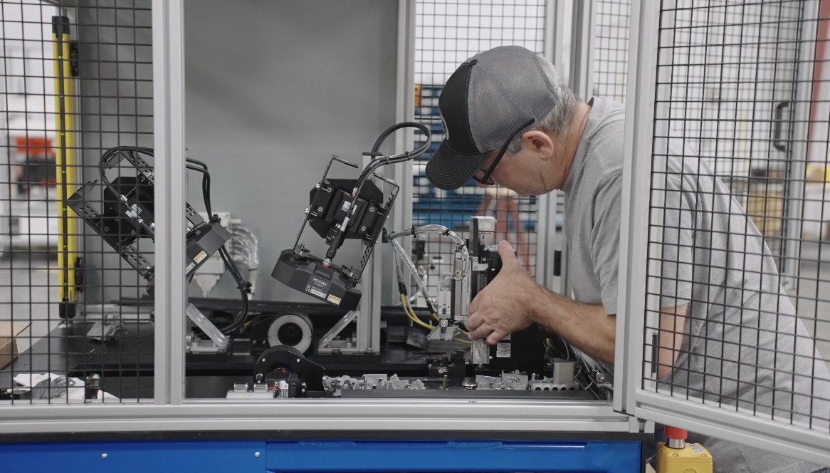 engineer working on robot in cell