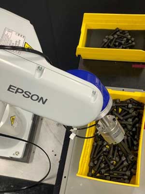 Figure 1: Using 3D vision, robots can pick objects directly from bins, eliminating the need for additional equipment to empty and separate parts. This leads to a more compact and efficient bin emptying process. (Image courtesy of Epson)