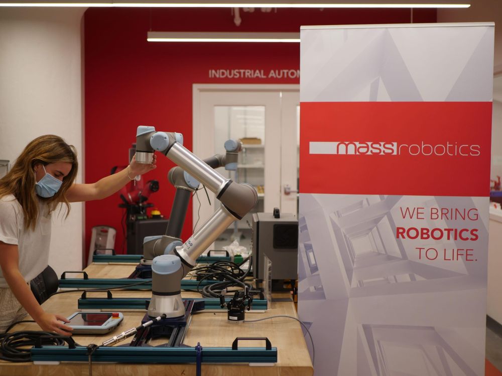 person interacting with a robot arm