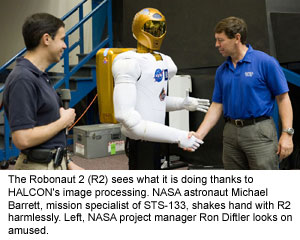 The Robonaut 2 (R2) sees what it is doing thanks to HALCON's image processing. NASA astronaut Michael Barrett, mission specialist of STS-133, shakes hand with R2 harmlessly. Left, NASA project manager Ron Diftler looks on amused.