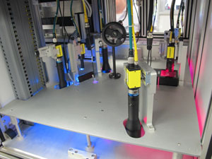 The Vision sub-system, viewed from above the rotary disc (located below the metal surface). Here, the six Cognex cameras with their lenses can be seen. This picture was taken from the back of the equipment.