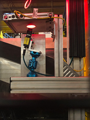 A robot removes a part from the mold and presents both sides of the part to a Cognex In-Sight 7000 smart camera located on top of the mold press.