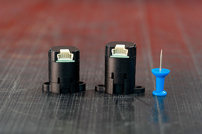 US Digital M3K Miniature Magnetic Encoder next to a standard thumbtack