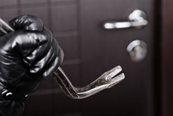 Burglar about to break into a house through the door