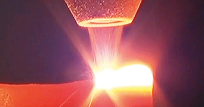 Figure 1: Image shows selective laser melting, a type of powder-bed fusion in which material is deposited, then fused by laser beam. (Courtesy of Siemens Industry)