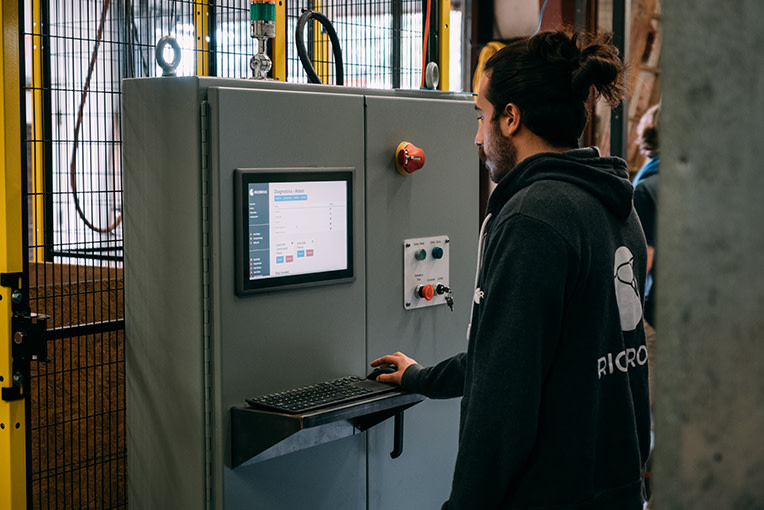 A man standing in front of and interacting with HMI solution