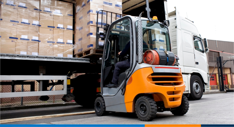 A photo of a forklift placing a pallet on to a truck