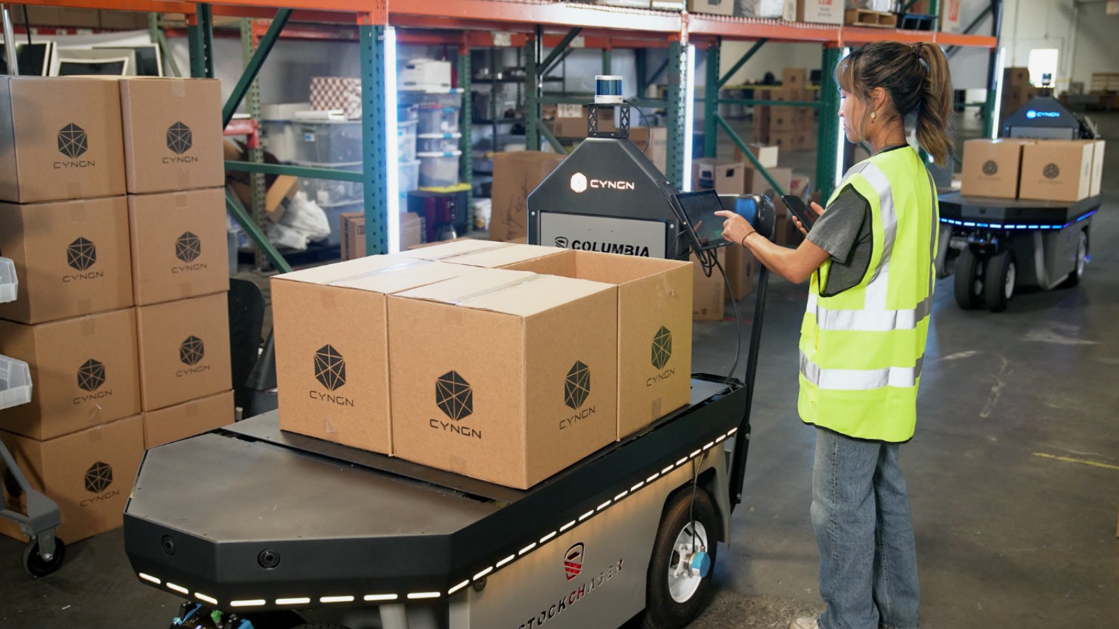 warehouse worker loading boxes onto an AMR