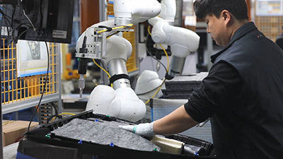 Human workers and collaborative robots work as a team on the assembly line. (Courtesy Doosan Robotics Inc.)