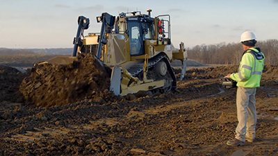 An equipment operator uses an over-the-shoulder remote console for line-of-sight control of an autonomous bulldozer up to a quarter mile away. (Courtesy of Caterpillar Inc.)