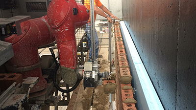 Robotic bricklaying system applies mortar and precisely positions bricks on the wall according to a digital blueprint. (Courtesy of Construction Robotics)