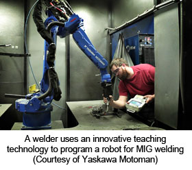 A welder uses an innovative teaching technology to program a robot for MIG welding (Courtesy of Yaskawa Motoman)