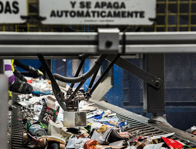 A picture of a robot and vision system in use on a recycling conveyor.