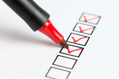 A checklist being marked with a red pen