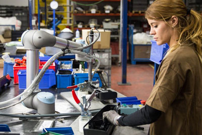 A picture of a worker and cobot working in manufacturing facility.