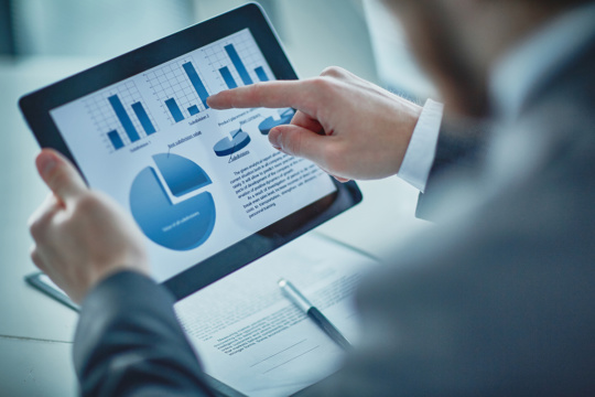 An employee reviewing data in charts and graphs before a business meeting. An employee reviewing data in charts and graphs before a business meeting.