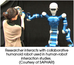 Researcher interacts with collaborative humanoid robot used in human-robot interaction studies (Courtesy of SAPHARI)