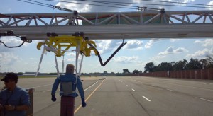 A crash test dummy used in a crash avoidance test systems, hangs from a MacBUILT actuator mounted to a cantilevered MacFRAME structure.