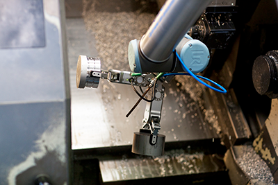 A dual gripper enables the collaborative robot arm to handle more parts at a time, increasing productivity in this CNC machine tending application. (Courtesy of On Robot A/S)